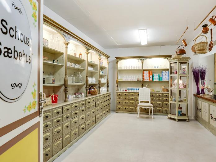 Rum indrettet som gammeldags apotek kaldet ”Schous Søbehus” med udstillede varer på hylderne, medicinskuffer og en disk.