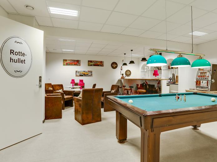 Fælles opholdsrum kaldet ”Rottehullet” indrettet som bodega med billardbord, bardisk, spillemaskine og brune siddemøbler.