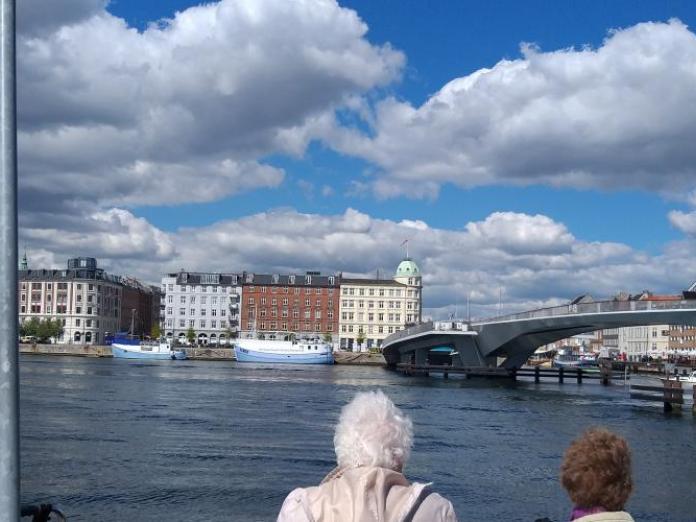 Kig fra Christianshavn over mod Nyhavn, hvor man kan se gamle fiskerbåde lagt til kaj og den nye gang- og cyklebro, Inderhavnsbroen, der forbinder Nyhavn med Christianshavn.