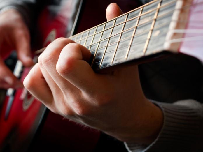 Nærbillede af person, der spiller guitar.