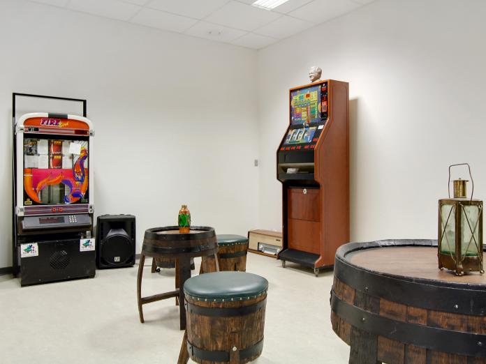 Rum indrettet som brun bodega med spillemaskiner og møbler lavet af gamle øltønder.
