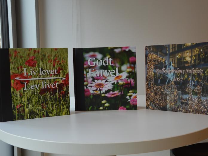 Tre bøger udgivet af Fælledgården. Titlerne er "Liv levet - lev livet", "Godt Farvel" og "Fælledgårdens Julebog 2021".