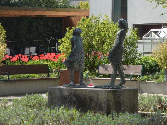 Skulptur i haven af to piger.